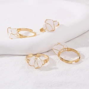 Detailed shot of four handmade wire-wrapped rings with raw white crystal quartz stones