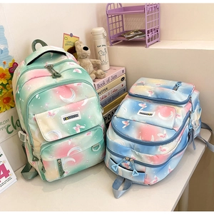 Detail of gradient school backpacks with moon and butterfly prints in a student setting