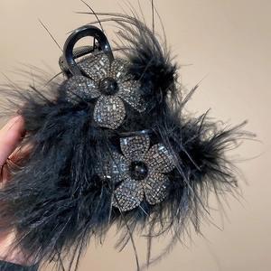 Détail de fleurs en strass étincelants et plumes noires sur une pince à cheveux de luxe