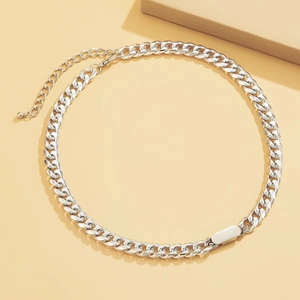 Silver chunky curb chain necklace with a polished rectangle pendant on a beige surface