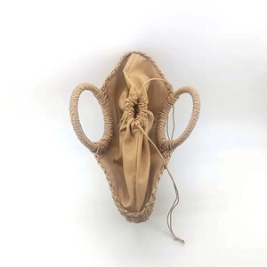 Detailed top view of moon-shaped straw handbag with drawstring closure and inner lining