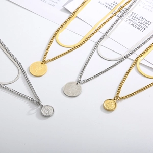 Detail of layered gold and silver coin necklaces featuring flat snake and cable chains