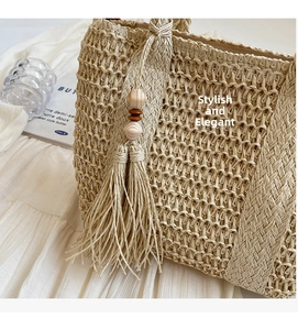 Detailed weave pattern of the beige straw tote bag with elegant tassel and wood bead charm