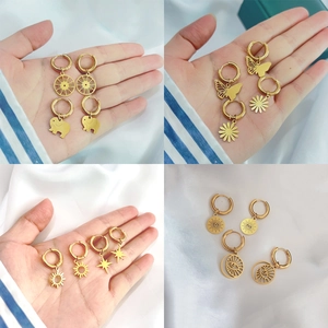 18K gold plated stainless steel earring set featuring star and evil eye charms on silk