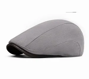Detail of light gray newsboy cap with textured linen fabric and brown faux leather trim