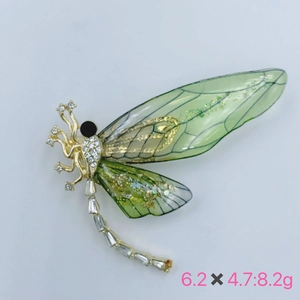 Macro view of a green dragonfly brooch with white zircons and dimensions 6.2x4.7cm