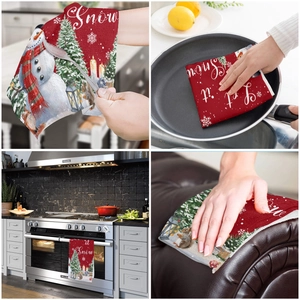 Detail view of Christmas kitchen towel featuring snowman print and Let it Snow text