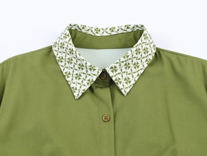 Detail of elegant green shirt collar with white geometric print and matching buttons