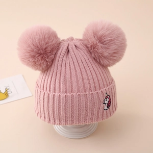 Detailed knit texture and embroidered unicorn on pink winter hat with double pom poms