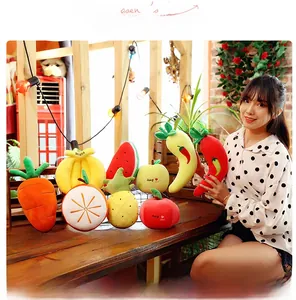 Assorted plush fruit and vegetable toys including carrot, watermelon and banana on wood