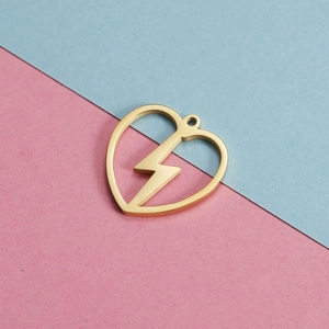 Minimalist gold stainless steel hollow heart pendant with lightning bolt design on paper