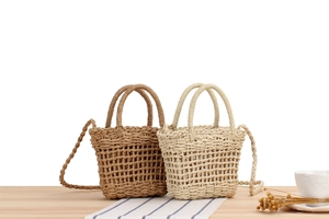 Detail of woven straw handbags in khaki and beige with natural paper rope texture