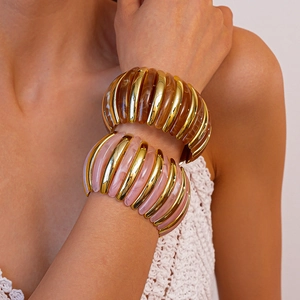 Detail of stacked amber and purple marble acrylic bracelets with gold metal accents