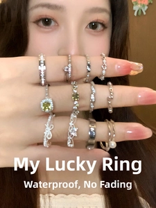 Detail of diverse silver rings featuring zircon stones and heart bow designs on hand