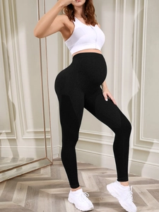 Detail of high-waist maternity yoga pants in black with breathable side mesh texture