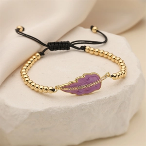 Adjustable woven bracelet with gold beads and a purple enamel leaf charm on stone