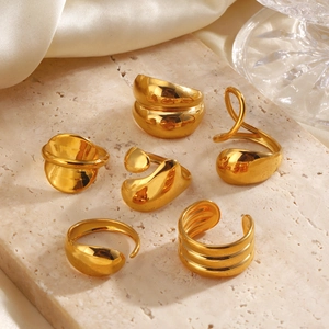Chunky organic geometric gold rings with high polish finish on elegant marble backdrop