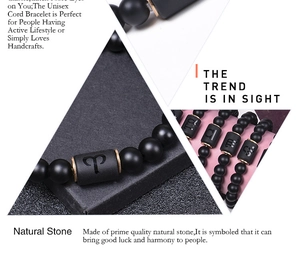 Macro view of matte black natural stone beaded bracelets with engraved zodiac signs