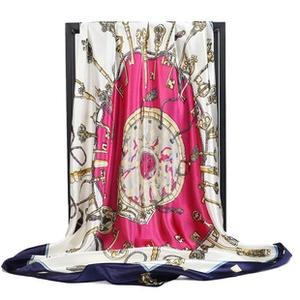 Detail of elegant satin square scarf featuring vintage key and chain patterns with fluid drape
