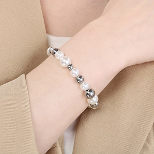 Détail d'un bracelet en perles d'eau douce blanches et perles argentées sur le poignet