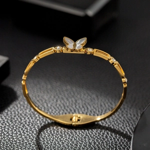 Detail of 18K gold butterfly bangle with white shell inlay and sparkling crystals