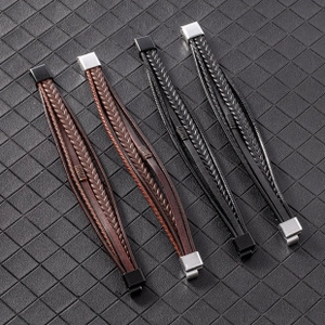 Detail view of woven leather bracelets in black and brown with diverse metal clasps