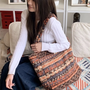 Close-up of retro geometric knitted tote bag with ethnic orange and brown patterns