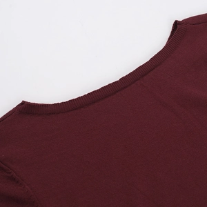 Primer plano del escote de un vestido de punto granate mostrando su fina textura