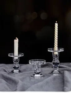 Three-piece set of transparent glass candle holders with elegant Roman pillar design