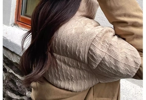 Detail showing the thick cable knit texture and warm fleece lining on the beige winter hat