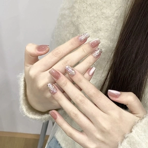 Pink cat eye press-on nails with glitter accents on a square-round shape manicure