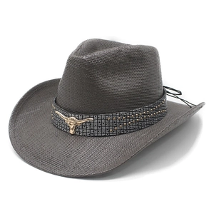 Vintage dark gray straw cowboy hat with a gold bull head emblem and wide brim