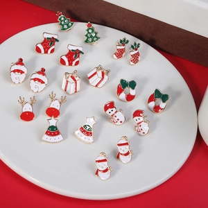9-pair Christmas earring set with enamel Santa, snowman and reindeer on a white plate