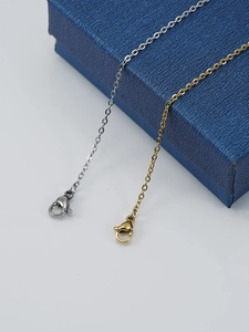 Close-up of gold and silver stainless steel cable chains with lobster clasp detail
