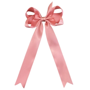 Detailed view of pink satin bow hair clip with layered ribbons and swallowtail ends