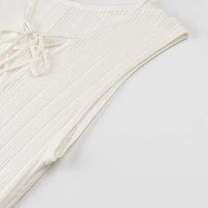 Detail of white ribbed knit fabric featuring a deep V-neckline with lace-up tie design