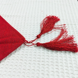 Red Christmas table runner with festive fabric texture and elegant tassel detail