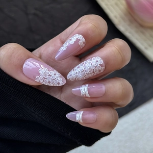 Detailed view of almond-shaped nails with pink purple base, 3D floral art and small pearls