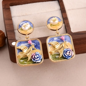 Detail of oil painting floral earrings with bird and rose motifs and pearl accents