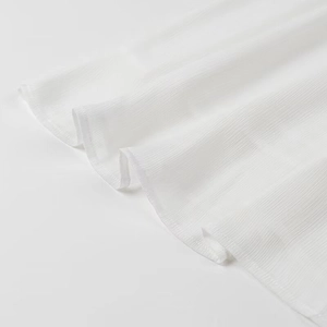 Detail shot of the white pleated hem and textured fabric of the summer long dress