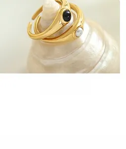 Détails de bagues dorées à l'or 18 carats avec perle noire et perle blanche élégante