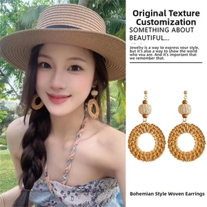 Detail of bohemian raffia drop earrings on a model and close-up view for beach vacation