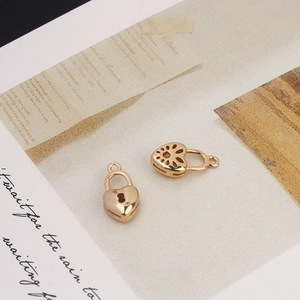 Detail view of heart-shaped gold-plated pendants with lock patterns for DIY jewelry making