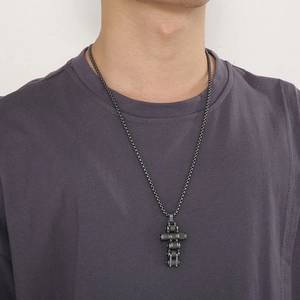 Close-up of industrial bike chain cross pendant on a titanium steel necklace for men