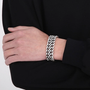 Close-up of a chunky vintage silver stainless steel chain bracelet on a male wrist