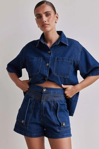 Nahaufnahme der Metallknöpfe und Nähte an dem dunkelblauen Denim-Hemd- und Shorts-Set