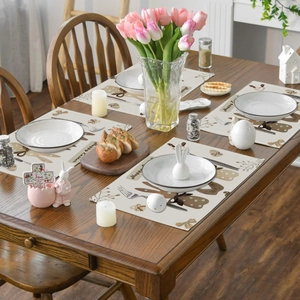 Set of four Easter linen placemats featuring brown rabbit patterns and Happy Easter text