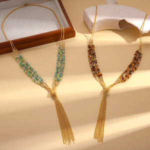 Bohemian multi-layer glass bead necklace with golden tassels on elegant stone stands