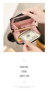 Detail of a black quilted short wallet for women with pink lining and pompom charm