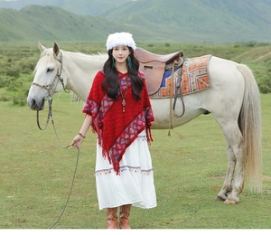 Ethnic style red knit poncho with geometric patterns and tassels for travel